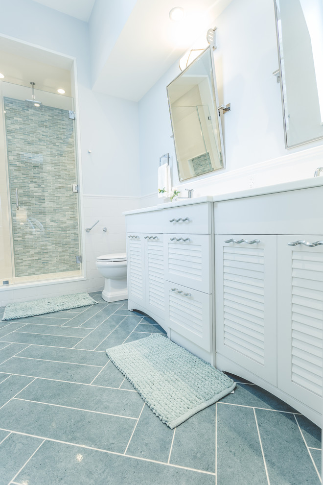 Inredning av ett modernt stort badrum för barn, med vita skåp, en öppen dusch, en toalettstol med hel cisternkåpa, grå kakel, blå väggar och ett nedsänkt handfat