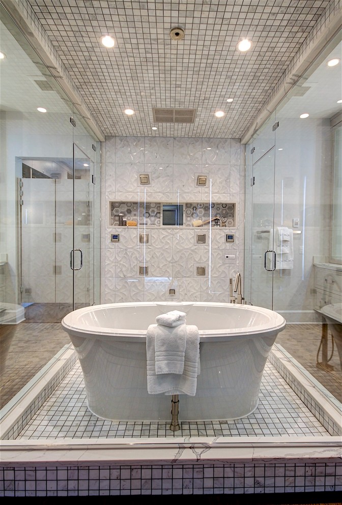 Klassisk inredning av ett en-suite badrum, med möbel-liknande, grå skåp, ett fristående badkar, våtrum, en bidé, grå kakel, marmorkakel, vita väggar, mellanmörkt trägolv, ett undermonterad handfat, bänkskiva i kvarts och dusch med gångjärnsdörr