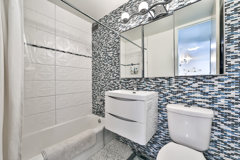 На фото: маленькая ванная комната в стиле ретро с стеклянными фасадами, ванной в нише, душем над ванной, раздельным унитазом, синей плиткой, стеклянной плиткой, синими стенами, полом из терраццо, подвесной раковиной, столешницей из искусственного камня, белым полом и белой столешницей для на участке и в саду с