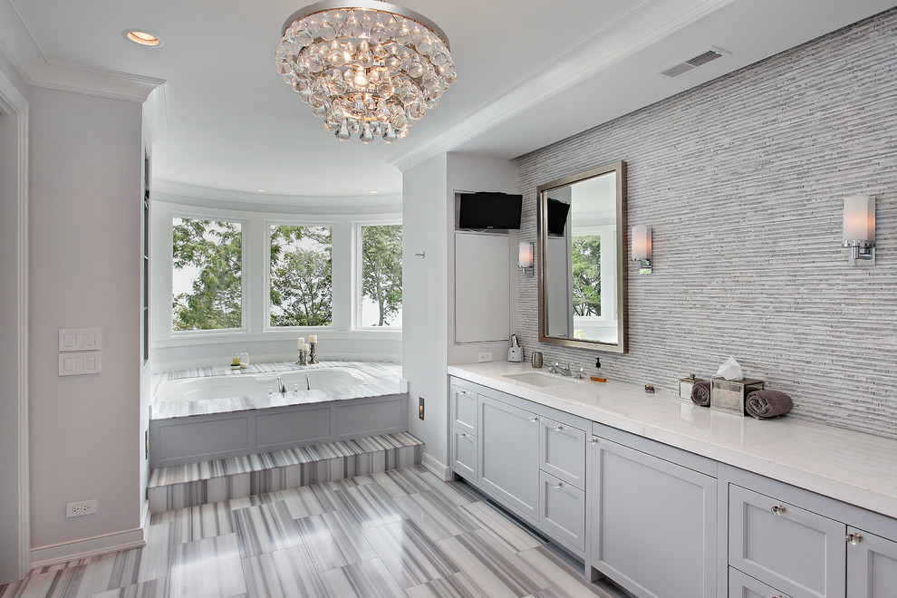 На фото: ванная комната: освещение в стиле неоклассика (современная классика) с удлиненной плиткой, серыми фасадами и серой плиткой с