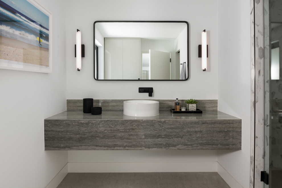 Idée de décoration pour une salle de bain design avec un mur blanc, une vasque, un sol gris et un plan de toilette gris.