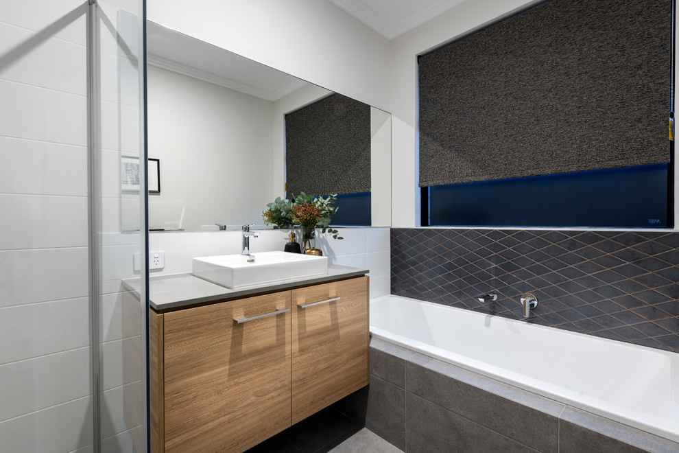 Inspiration for a medium sized contemporary ensuite bathroom in Perth with flat-panel cabinets, light wood cabinets, a built-in shower, white tiles, porcelain tiles, white walls, porcelain flooring, a built-in sink, concrete worktops, grey floors, a hinged door and grey worktops.