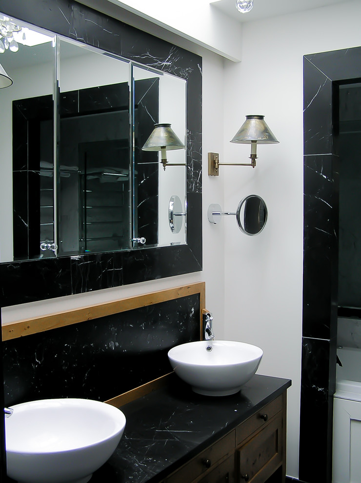 Foto di una stanza da bagno per bambini design di medie dimensioni con ante di vetro, ante nere, vasca ad alcova, WC sospeso, pareti bianche, lavabo a bacinella, top in marmo e top nero