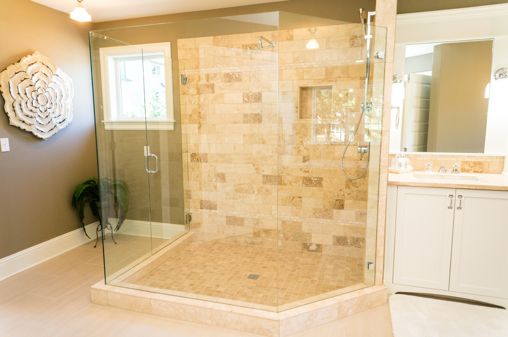 Klassisk inredning av ett stort en-suite badrum, med luckor med infälld panel, vita skåp, ett platsbyggt badkar, en dusch i en alkov, klinkergolv i porslin, ett undermonterad handfat, marmorbänkskiva, beige kakel, porslinskakel och bruna väggar