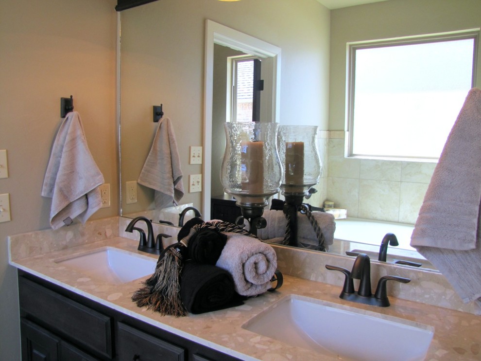 Klassisk inredning av ett mellanstort en-suite badrum, med ett undermonterad handfat, luckor med upphöjd panel, skåp i mörkt trä, bänkskiva i kvarts, ett badkar i en alkov, beige kakel, keramikplattor och beige väggar