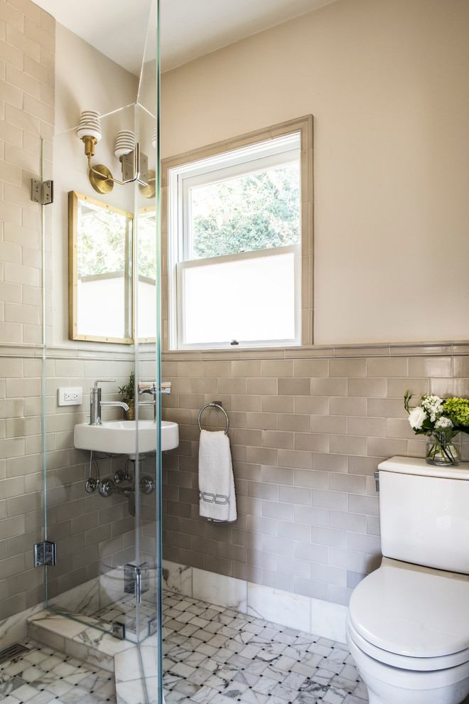Example of a transitional gray tile corner shower design in San Francisco with a wall-mount sink, a two-piece toilet, white walls and a hinged shower door