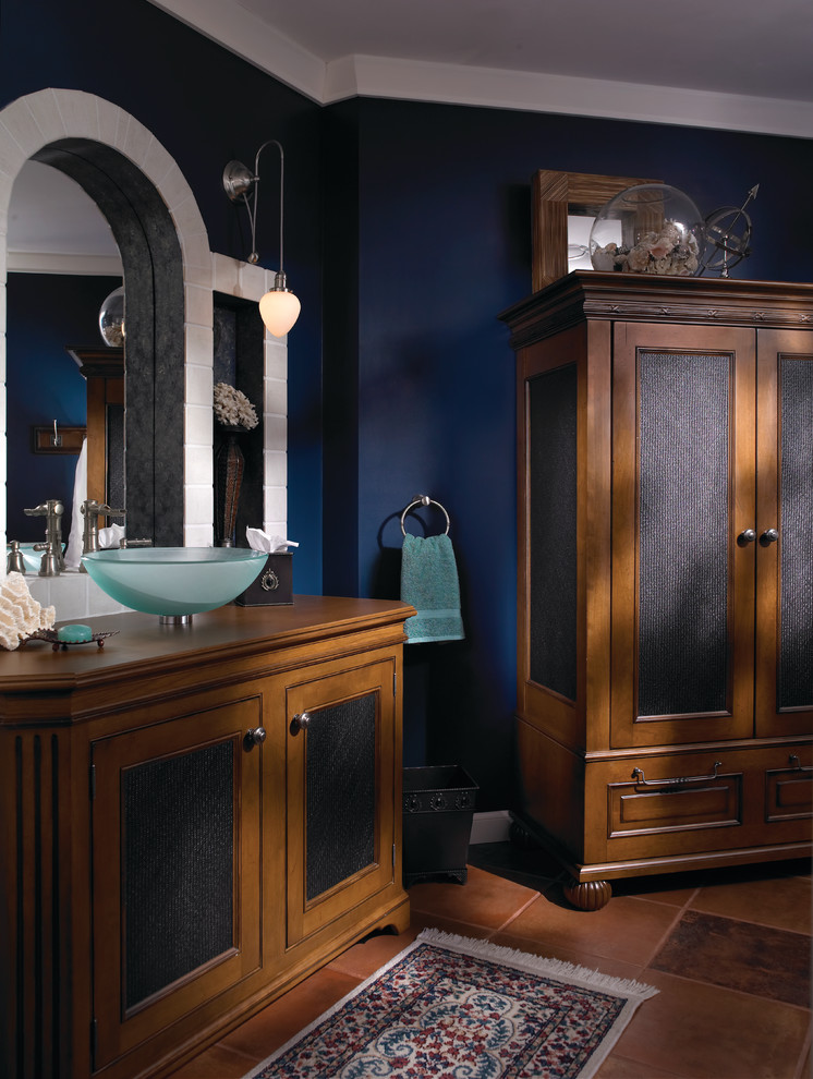 Klassisk inredning av ett mellanstort en-suite badrum, med ett fristående handfat, möbel-liknande, skåp i mellenmörkt trä, träbänkskiva, ett badkar med tassar, en hörndusch, en bidé, porslinskakel, blå väggar, klinkergolv i terrakotta och brun kakel