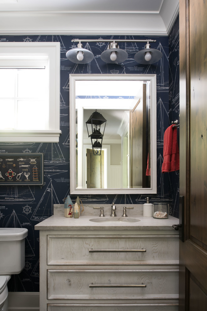 ミネアポリスにあるビーチスタイルのおしゃれなバスルーム (浴槽なし) (落し込みパネル扉のキャビネット、白いキャビネット、青い壁、アンダーカウンター洗面器) の写真