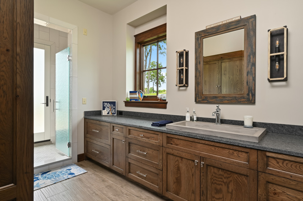 Example of a small arts and crafts master light wood floor and brown floor wet room design in Kansas City with flat-panel cabinets, medium tone wood cabinets, beige walls, a drop-in sink, a hinged shower door and gray countertops
