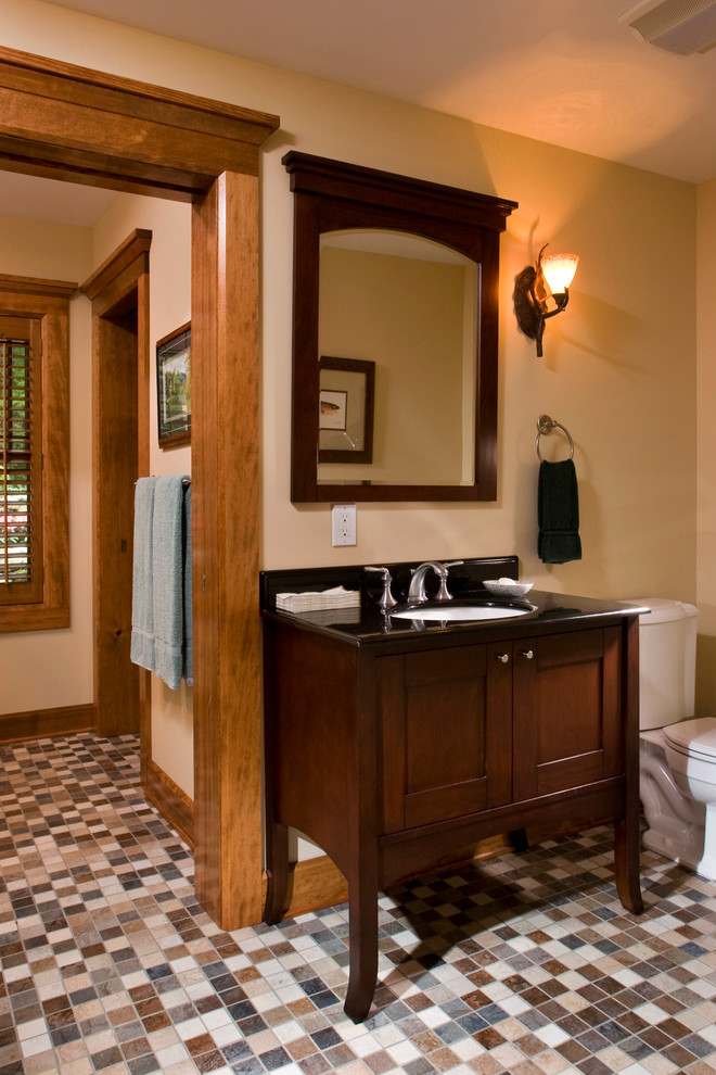 На фото: большая главная ванная комната в стиле рустика с темными деревянными фасадами, угловой ванной, унитазом-моноблоком, разноцветной плиткой, каменной плиткой, желтыми стенами, полом из мозаичной плитки, врезной раковиной и фасадами в стиле шейкер