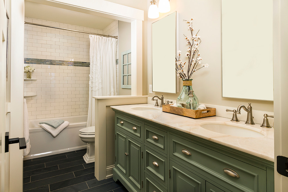 Пример оригинального дизайна: ванная комната среднего размера в классическом стиле с зелеными фасадами, ванной в нише, душем над ванной, раздельным унитазом, белой плиткой, плиткой кабанчик, бежевыми стенами, полом из сланца, врезной раковиной, мраморной столешницей и фасадами с выступающей филенкой