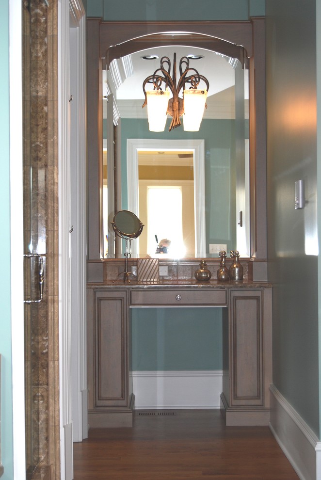 Réalisation d'une grande salle de bain principale chalet en bois brun avec un lavabo encastré, un placard avec porte à panneau surélevé, une baignoire posée, une douche d'angle, WC à poser, un carrelage beige, un carrelage de pierre, un mur vert et un sol en bois brun.