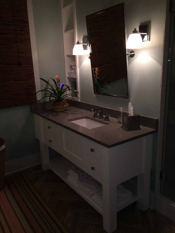 Cette photo montre une salle d'eau chic de taille moyenne avec un placard à porte plane, des portes de placard blanches, WC à poser, un carrelage blanc, un mur vert et un lavabo encastré.