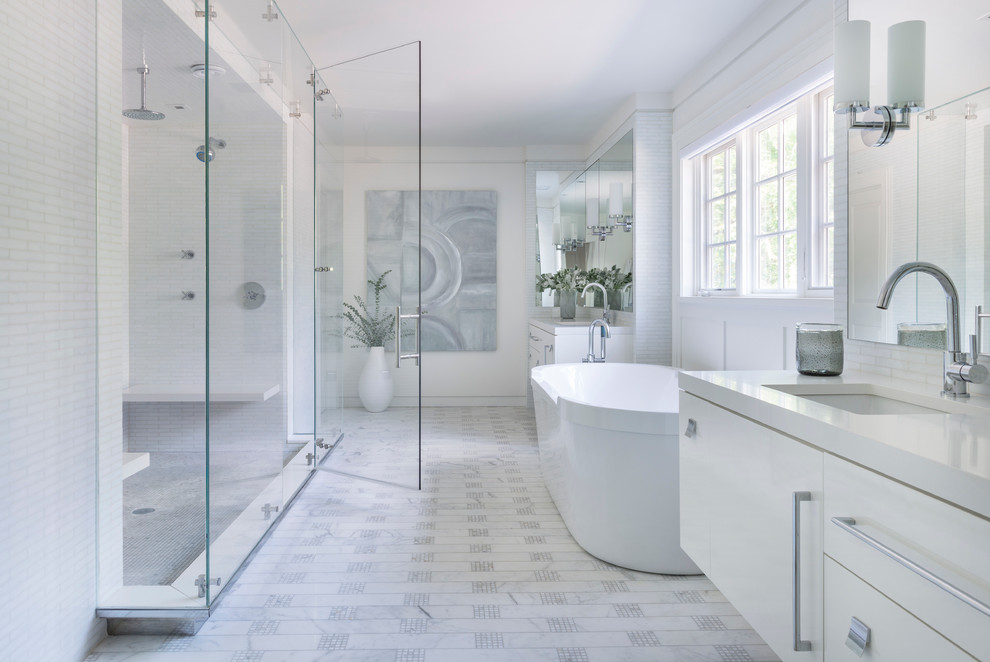Classic ensuite bathroom in New York with a submerged sink, flat-panel cabinets, white cabinets, a freestanding bath, an alcove shower, white tiles and white walls.