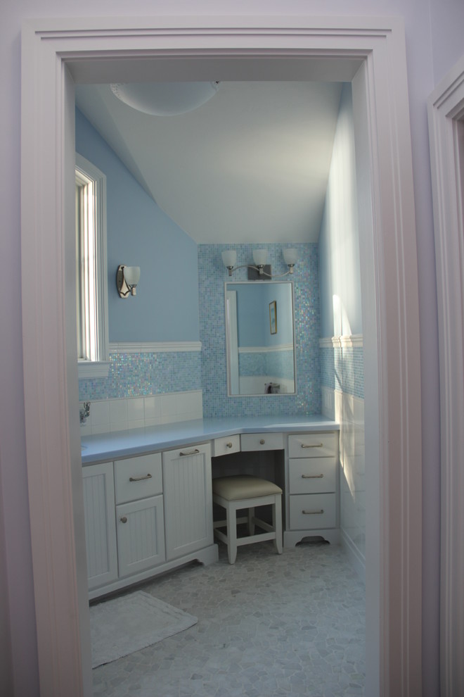 Foto de cuarto de baño infantil tradicional renovado de tamaño medio con lavabo bajoencimera, armarios con paneles empotrados, puertas de armario blancas, encimera de acrílico, combinación de ducha y bañera, sanitario de una pieza, baldosas y/o azulejos azules, paredes azules, suelo de mármol y bañera encastrada