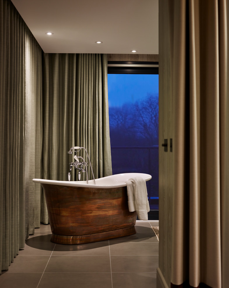 Diseño de cuarto de baño contemporáneo con bañera exenta y suelo gris