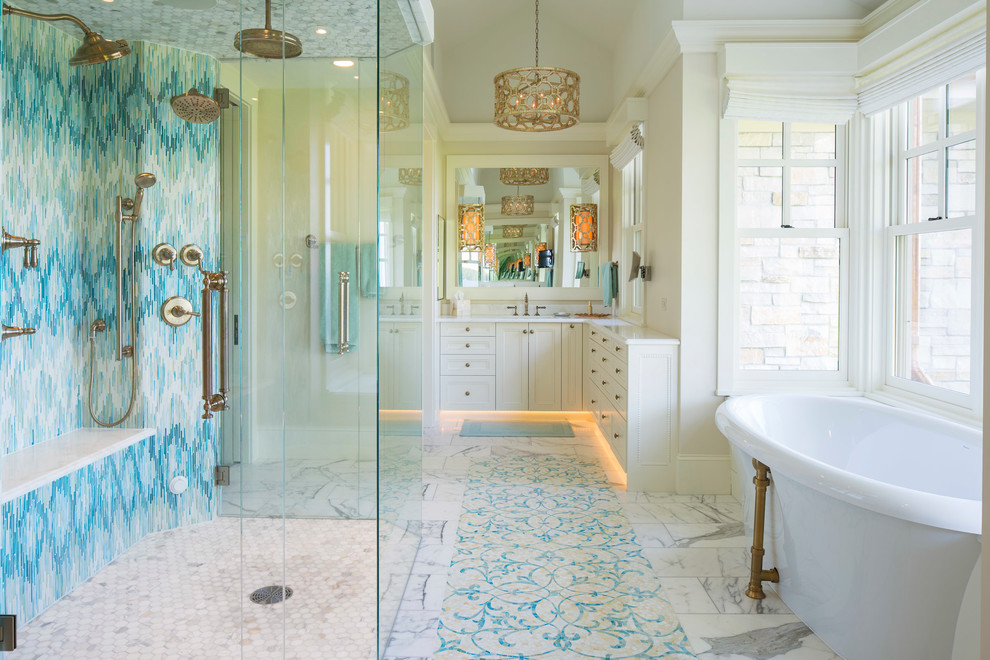 На фото: главная ванная комната в классическом стиле с мраморным полом, белыми фасадами, отдельно стоящей ванной, душем без бортиков, синей плиткой, разноцветной плиткой, белой плиткой, бежевыми стенами и зеркалом с подсветкой