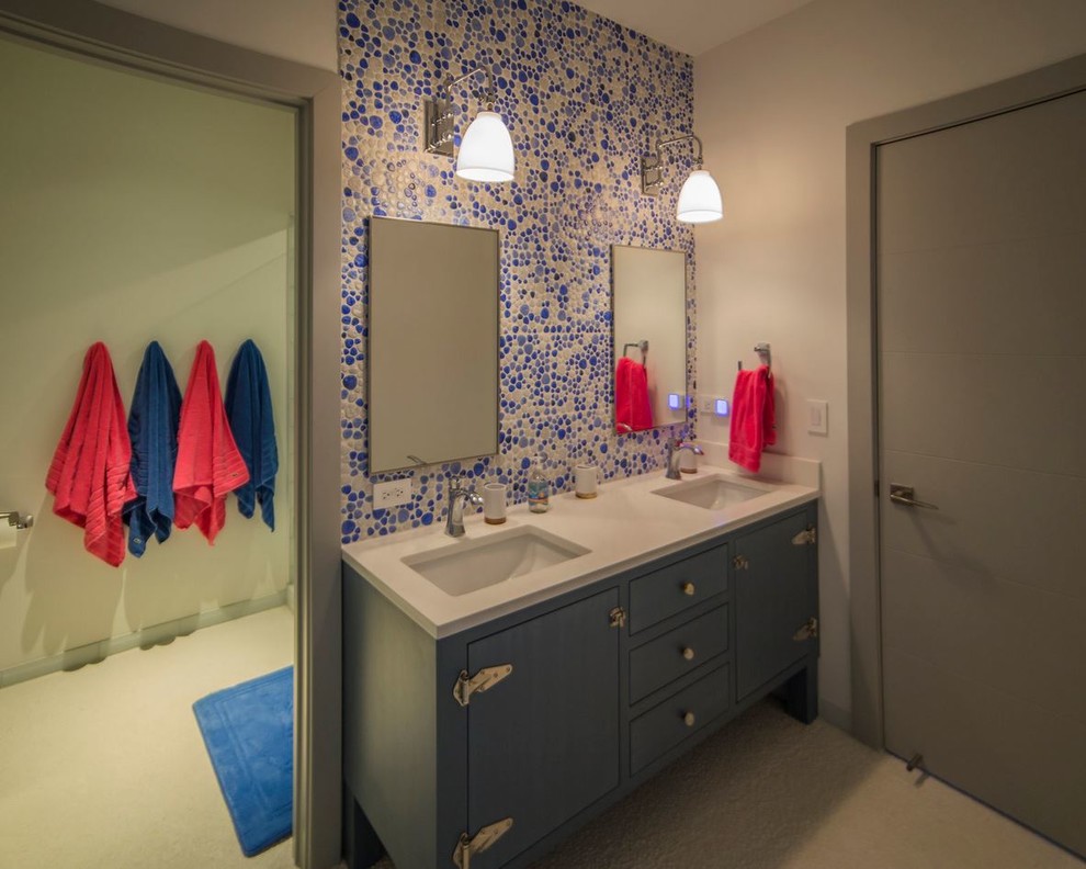 Idée de décoration pour une grande salle de bain tradition pour enfant avec un lavabo encastré, un placard à porte plane, des portes de placard bleues, un plan de toilette en quartz modifié, un carrelage blanc, un carrelage de pierre, un mur blanc et un sol en galet.