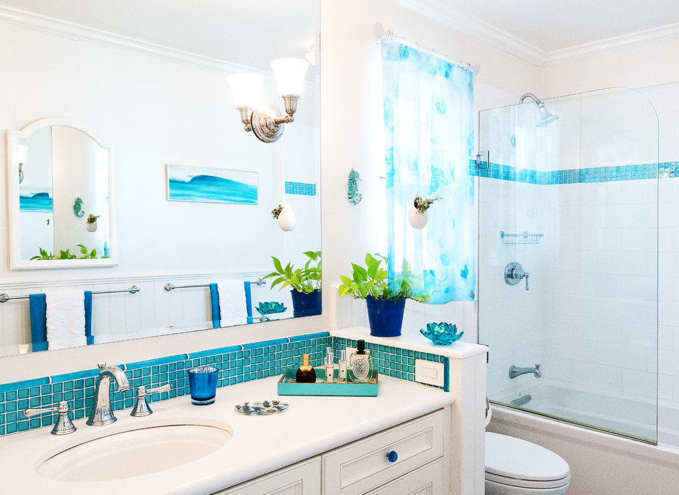Источник вдохновения для домашнего уюта: ванная комната в морском стиле с врезной раковиной, фасадами с утопленной филенкой, мраморной столешницей, душем над ванной, унитазом-моноблоком, синей плиткой, стеклянной плиткой и белыми стенами
