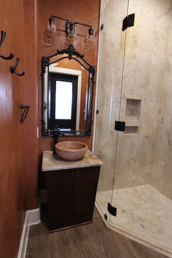 Идея дизайна: ванная комната среднего размера в средиземноморском стиле с плоскими фасадами, темными деревянными фасадами, угловым душем, раздельным унитазом, бежевой плиткой, плиткой из травертина, оранжевыми стенами, темным паркетным полом, душевой кабиной, настольной раковиной, столешницей из искусственного кварца, коричневым полом и душем с распашными дверями