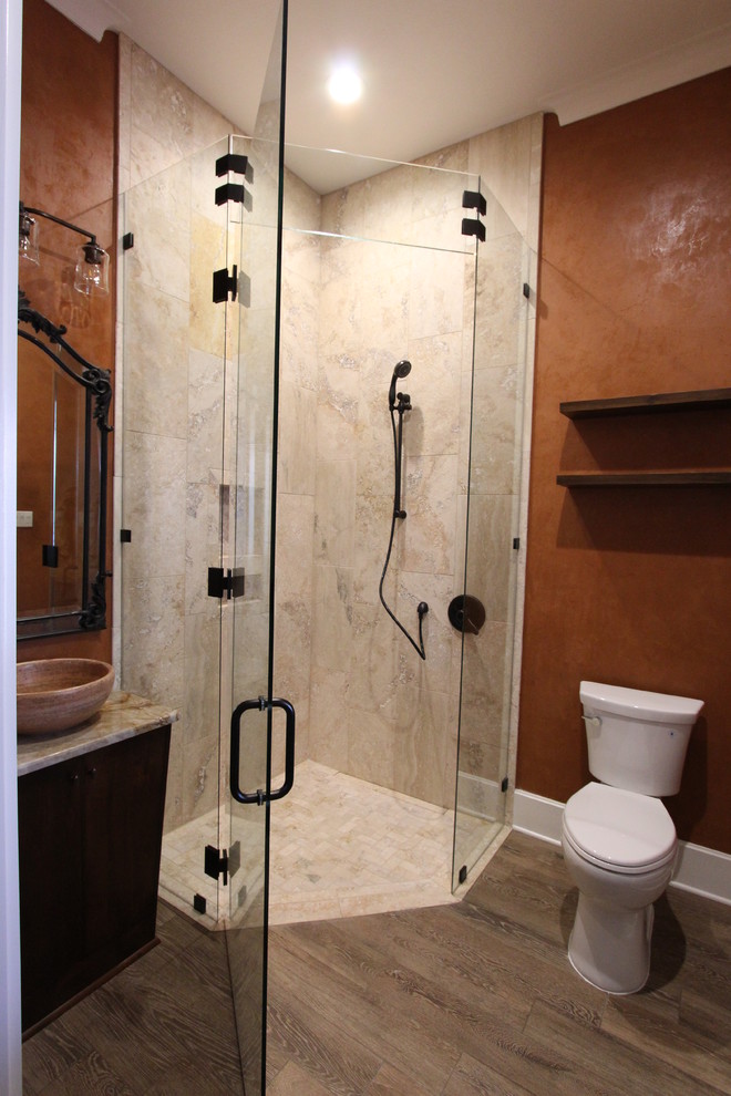 На фото: ванная комната среднего размера в средиземноморском стиле с плоскими фасадами, темными деревянными фасадами, угловым душем, раздельным унитазом, бежевой плиткой, плиткой из травертина, оранжевыми стенами, темным паркетным полом, душевой кабиной, настольной раковиной, столешницей из искусственного кварца, коричневым полом и душем с распашными дверями с