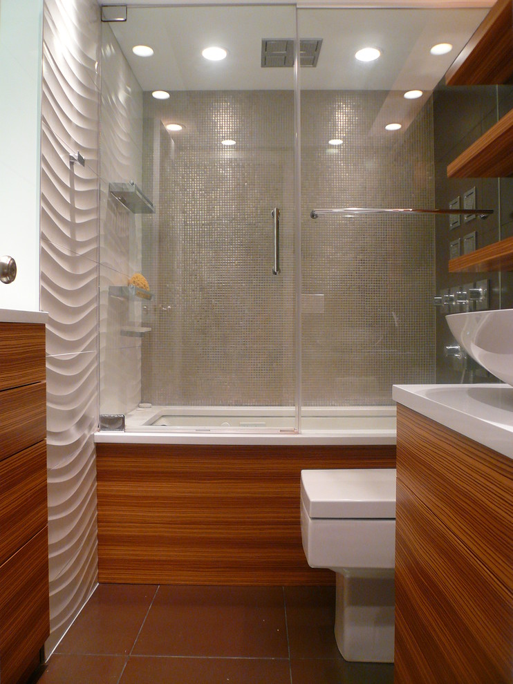 Example of a mid-sized minimalist gray tile and porcelain tile porcelain tile tub/shower combo design in Chicago with flat-panel cabinets, medium tone wood cabinets, an undermount tub, a one-piece toilet, white walls, a vessel sink and quartz countertops