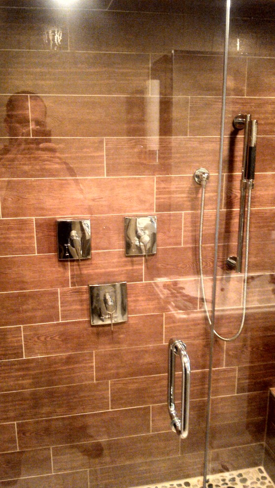 Exemple d'une douche en alcôve chic avec un carrelage marron et des carreaux de porcelaine.