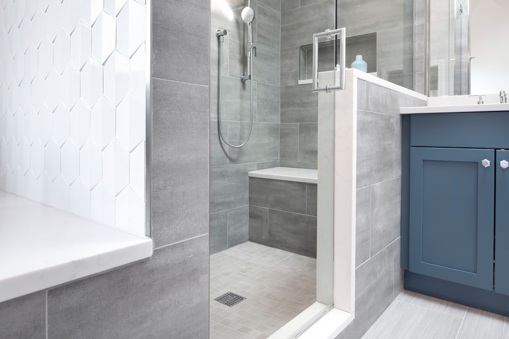 Idées déco pour une grande salle de bain principale classique avec un placard à porte shaker, des portes de placard bleues, une baignoire encastrée, une douche double, un carrelage gris, des carreaux de porcelaine, un mur gris, un sol en carrelage de porcelaine, un lavabo encastré, un plan de toilette en quartz modifié, un sol gris, une cabine de douche à porte battante et un plan de toilette blanc.