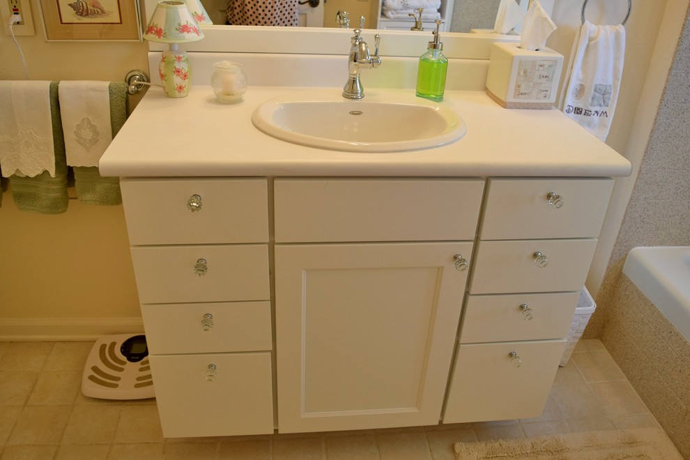 Klassisches Badezimmer mit Einbauwaschbecken, weißen Schränken, Laminat-Waschtisch, Einbaubadewanne, Duschbadewanne und weißer Wandfarbe in Denver