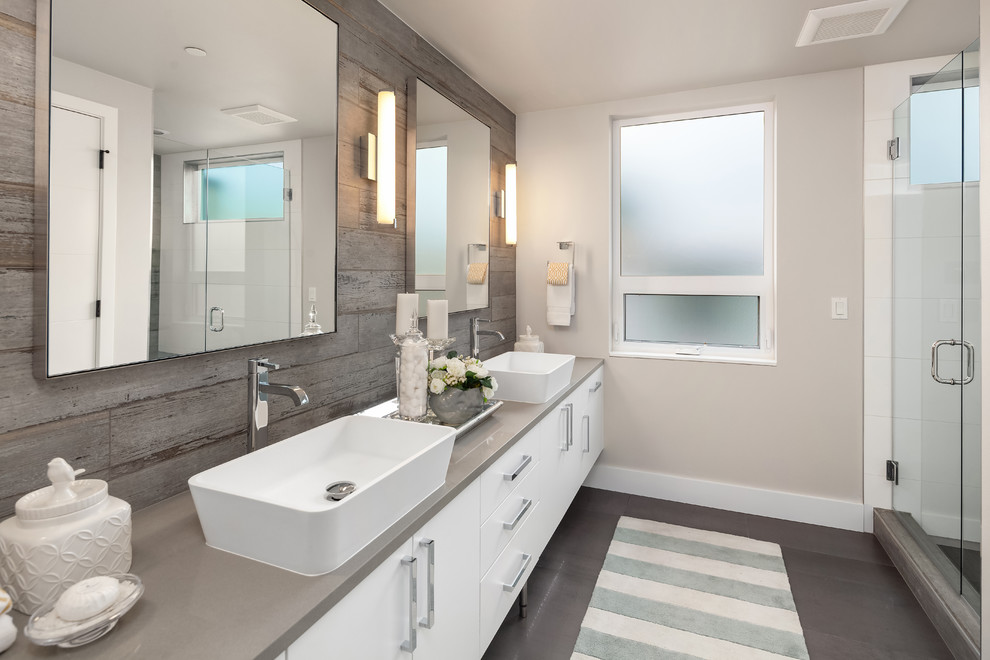 На фото: ванная комната в современном стиле с душем в нише, керамогранитной плиткой, полом из керамогранита, плоскими фасадами, белыми фасадами, белой плиткой, серыми стенами, настольной раковиной, серым полом, душем с распашными дверями и серой столешницей с