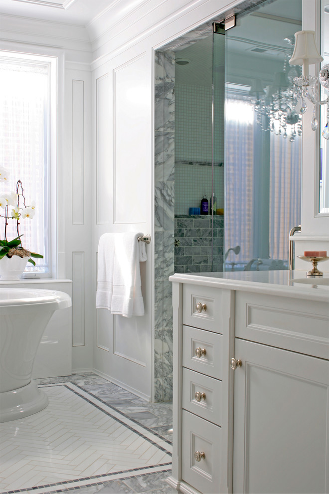 Exemple d'une très grande salle de bain principale chic avec un lavabo encastré, un placard avec porte à panneau encastré, des portes de placard blanches, un plan de toilette en marbre, une baignoire indépendante, une douche à l'italienne, WC séparés, un carrelage blanc, un carrelage de pierre, un mur blanc et un sol en marbre.