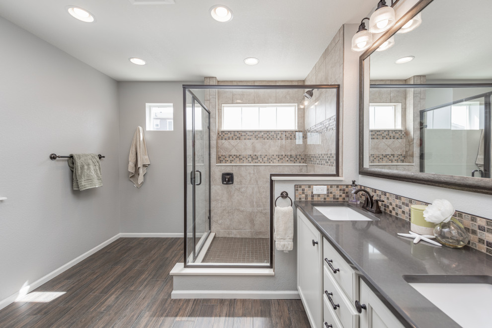 Design ideas for a modern bathroom in Los Angeles with flat-panel cabinets, white cabinets, a corner shower, multi-coloured tiles, ceramic tiles, grey walls, medium hardwood flooring, a submerged sink, quartz worktops, brown floors, a hinged door, grey worktops, an enclosed toilet, double sinks and a built in vanity unit.