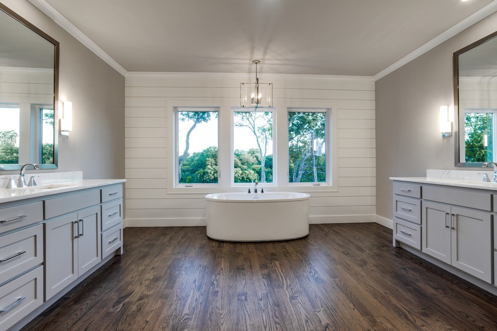 Large farmhouse ensuite bathroom in Dallas with shaker cabinets, grey cabinets, a built-in bath, grey walls, a submerged sink, marble worktops and dark hardwood flooring.