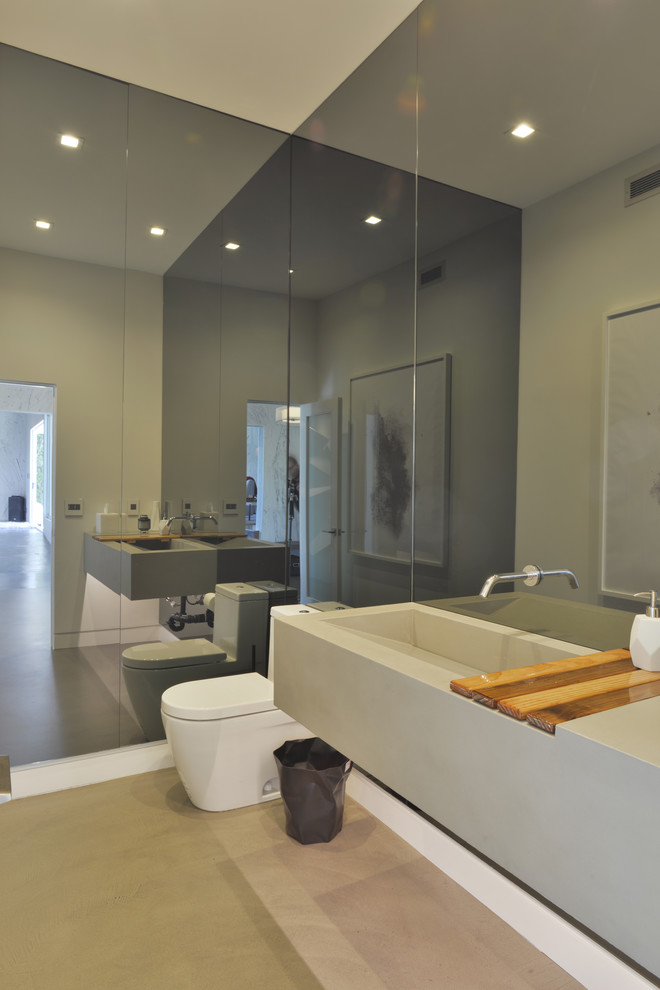 На фото: ванная комната среднего размера в стиле модернизм с унитазом-моноблоком, серыми стенами, бетонным полом, раковиной с несколькими смесителями и душевой кабиной с