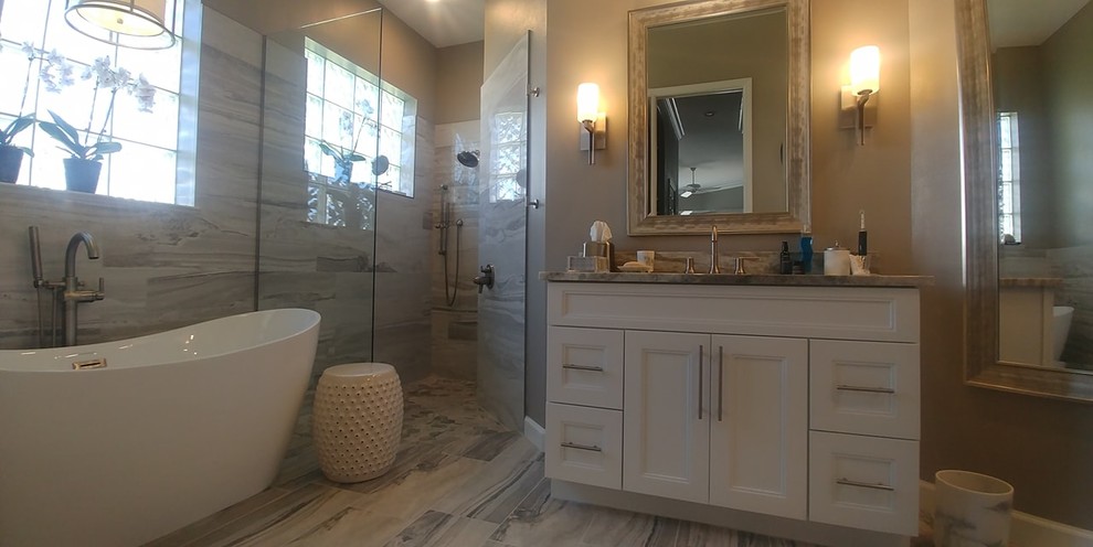 Design ideas for a large contemporary ensuite bathroom in Tampa with recessed-panel cabinets, white cabinets, a freestanding bath, a walk-in shower, porcelain tiles, porcelain flooring, a submerged sink, granite worktops and an open shower.