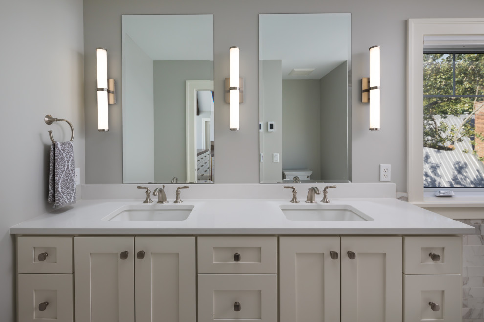 Inspiration for a large traditional ensuite bathroom in Grand Rapids with recessed-panel cabinets, beige cabinets, an alcove shower, a two-piece toilet, grey walls, a submerged sink, quartz worktops, grey floors, a hinged door, white worktops, double sinks, a built in vanity unit and marble flooring.