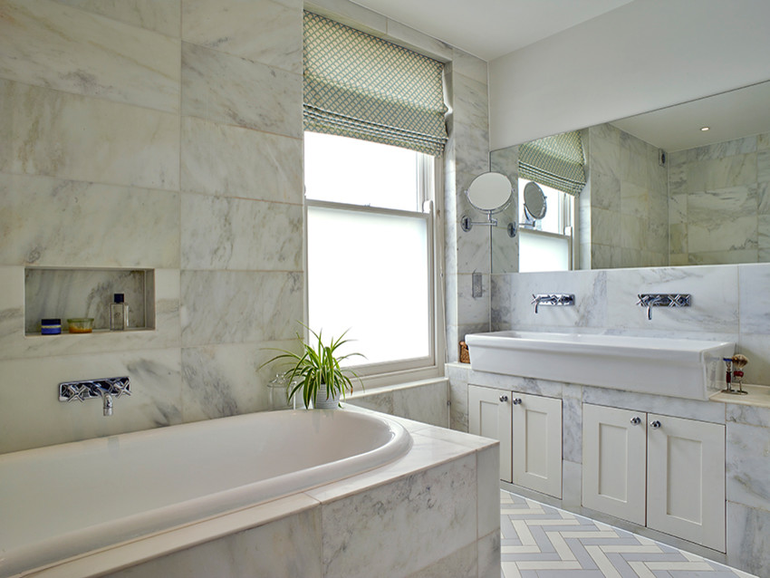 Foto på ett mellanstort vintage badrum, med luckor med infälld panel, ett platsbyggt badkar, marmorkakel, ett avlångt handfat och marmorbänkskiva