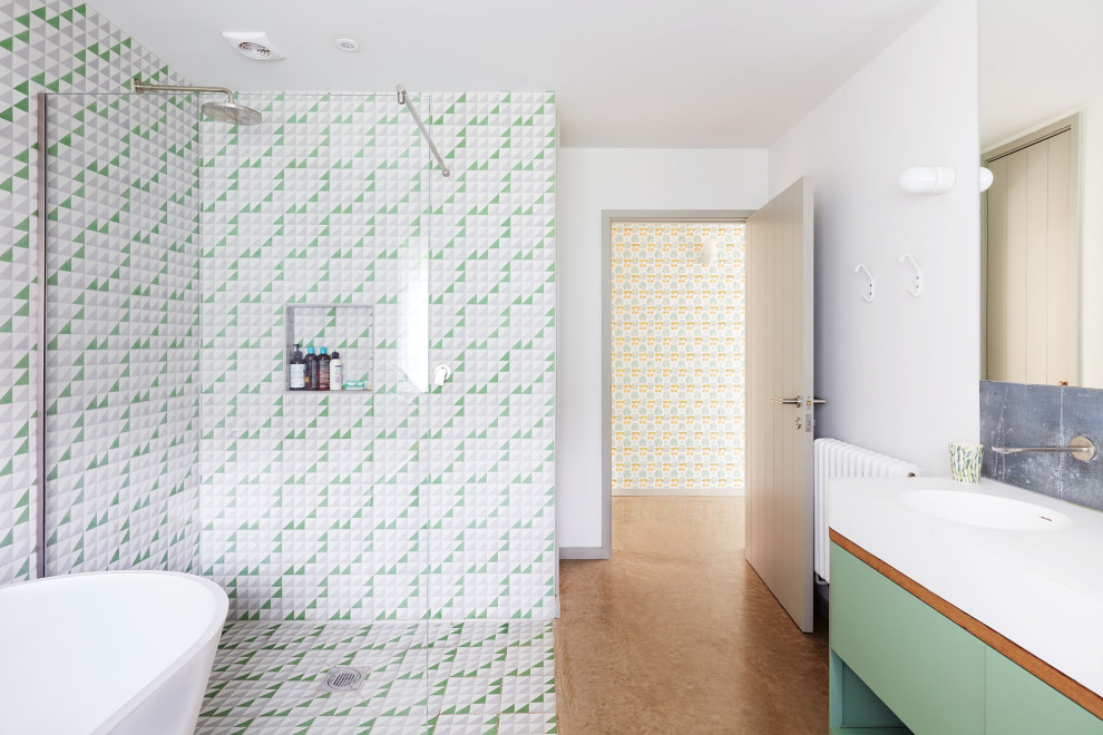 На фото: ванная комната среднего размера в скандинавском стиле с плоскими фасадами, зелеными фасадами, отдельно стоящей ванной, разноцветной плиткой, серой плиткой, зеленой плиткой, белой плиткой, керамогранитной плиткой, белыми стенами, бетонным полом, открытым душем, белой столешницей, угловым душем, монолитной раковиной и бежевым полом с