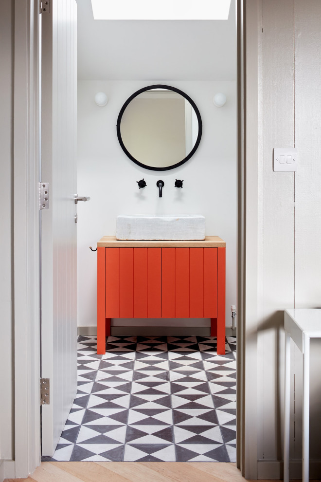 Foto på ett mellanstort skandinaviskt badrum med dusch, med möbel-liknande, röda skåp, vita väggar, klinkergolv i porslin, ett konsol handfat, träbänkskiva och flerfärgat golv