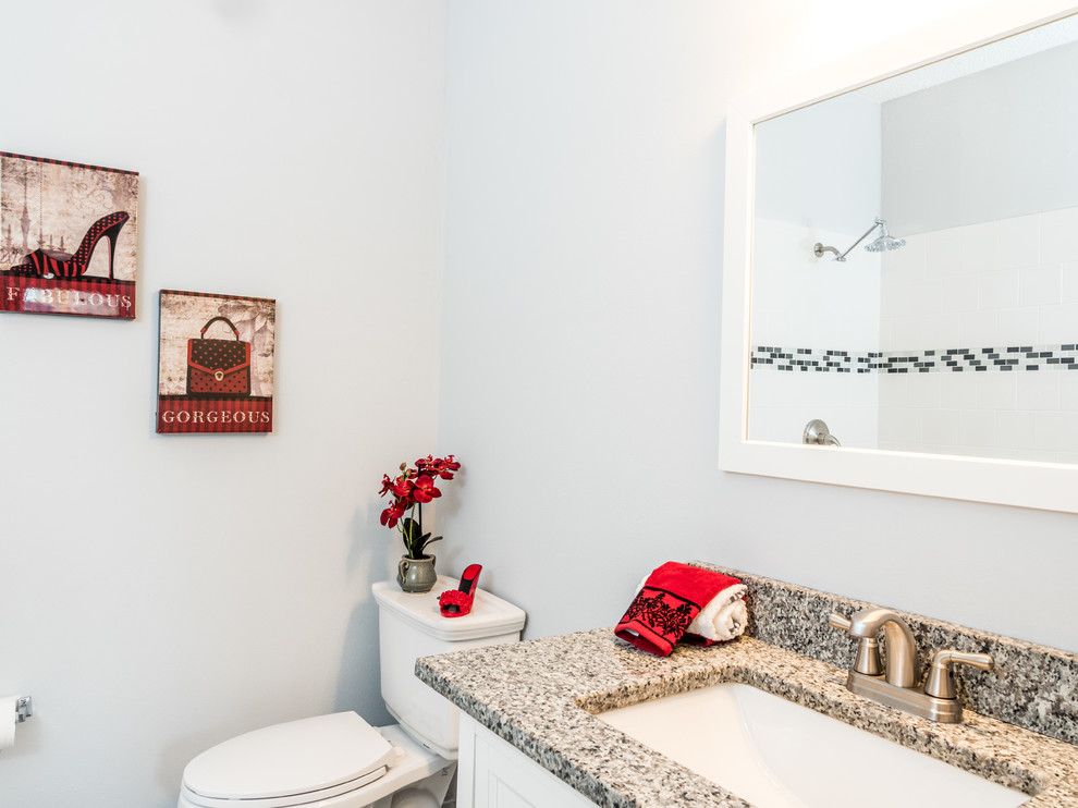オーランドにあるお手頃価格の広いトランジショナルスタイルのおしゃれなバスルーム (浴槽なし) (白いキャビネット、分離型トイレ、アンダーカウンター洗面器、御影石の洗面台) の写真