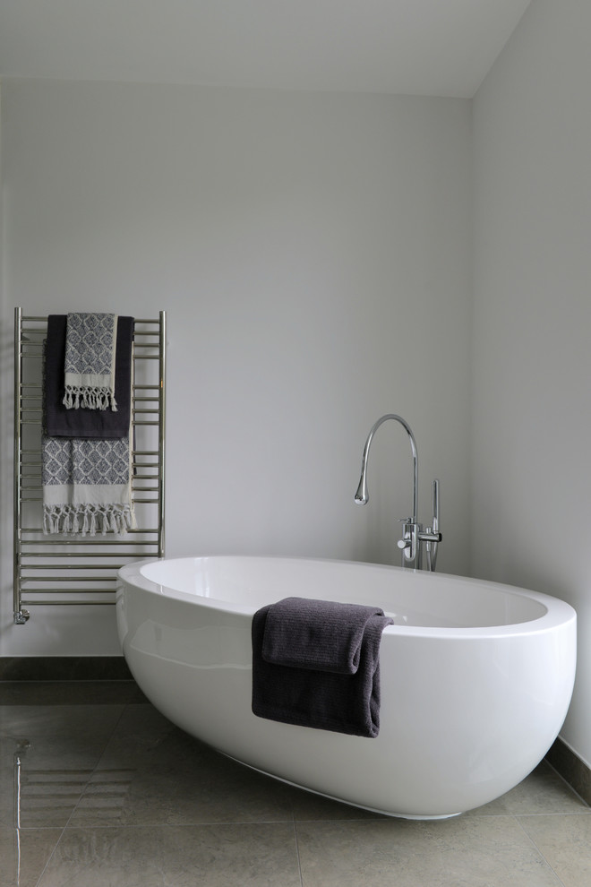This is an example of a medium sized contemporary ensuite bathroom in Gloucestershire with flat-panel cabinets, dark wood cabinets, a freestanding bath, a walk-in shower, a wall mounted toilet, brown tiles, porcelain tiles, white walls, porcelain flooring, a vessel sink and laminate worktops.