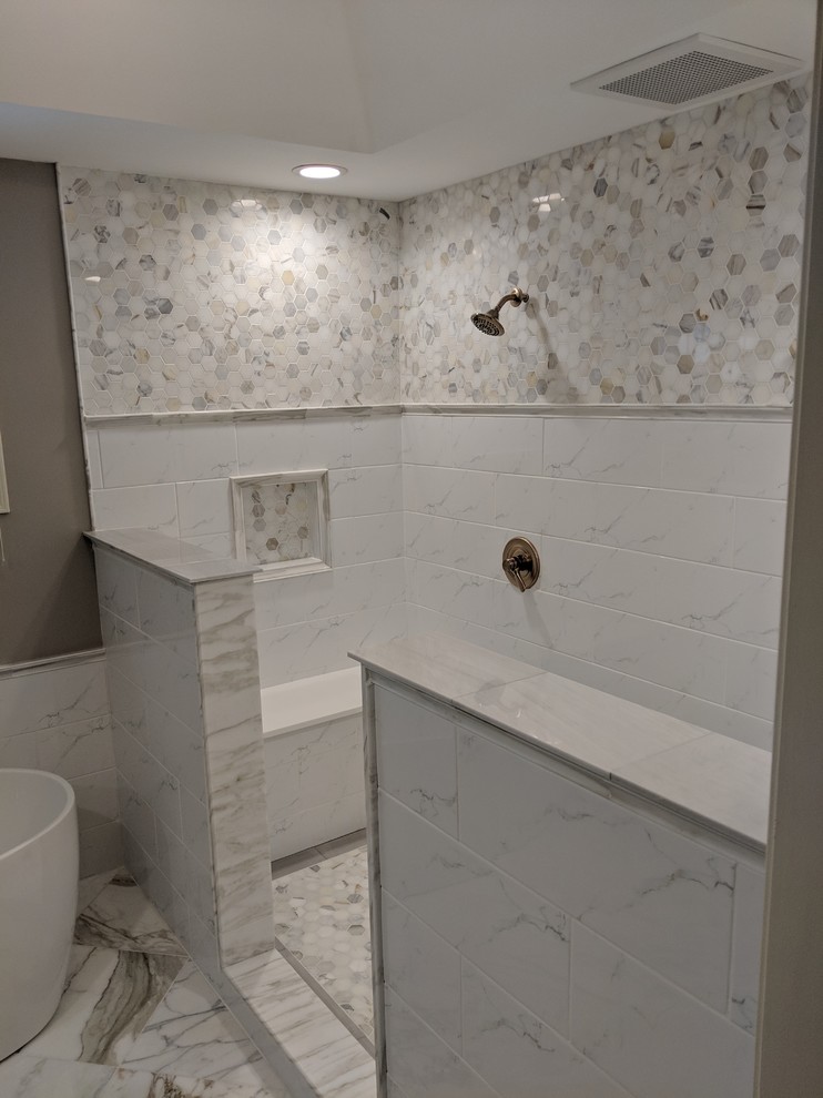 Aménagement d'une très grande salle de bain principale classique avec un placard avec porte à panneau encastré, des portes de placard grises, une baignoire indépendante, une douche ouverte, WC séparés, un carrelage blanc, du carrelage en marbre, un mur gris, un sol en marbre, un lavabo encastré, un plan de toilette en marbre, un sol blanc, aucune cabine et un plan de toilette blanc.