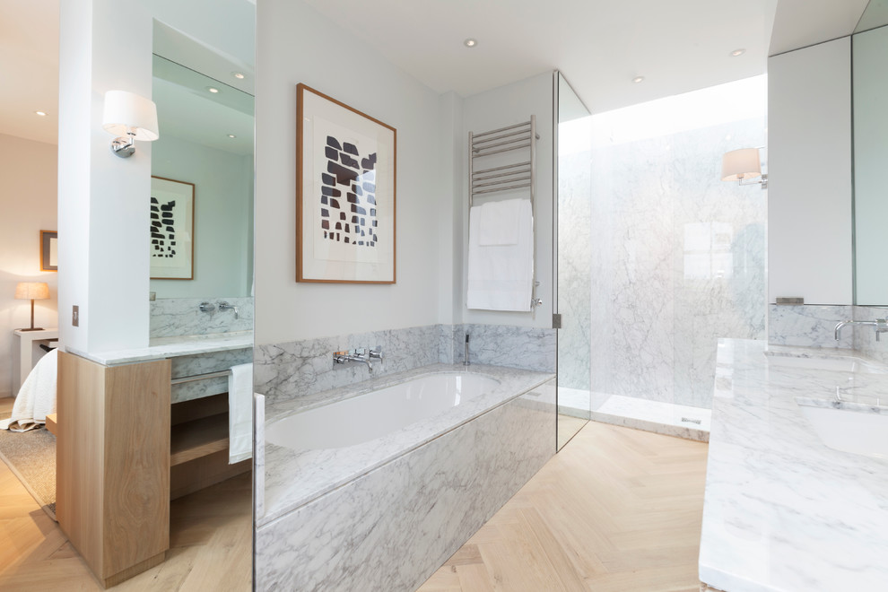 Photo of a medium sized modern ensuite bathroom in London with a submerged sink, open cabinets, medium wood cabinets, marble worktops, a built-in bath, a walk-in shower, a wall mounted toilet, white walls and light hardwood flooring.
