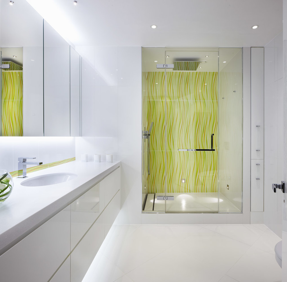 ロンドンにあるコンテンポラリースタイルのおしゃれな浴室 (アンダーカウンター洗面器、フラットパネル扉のキャビネット、白いキャビネット、アルコーブ型シャワー、白い壁、照明) の写真