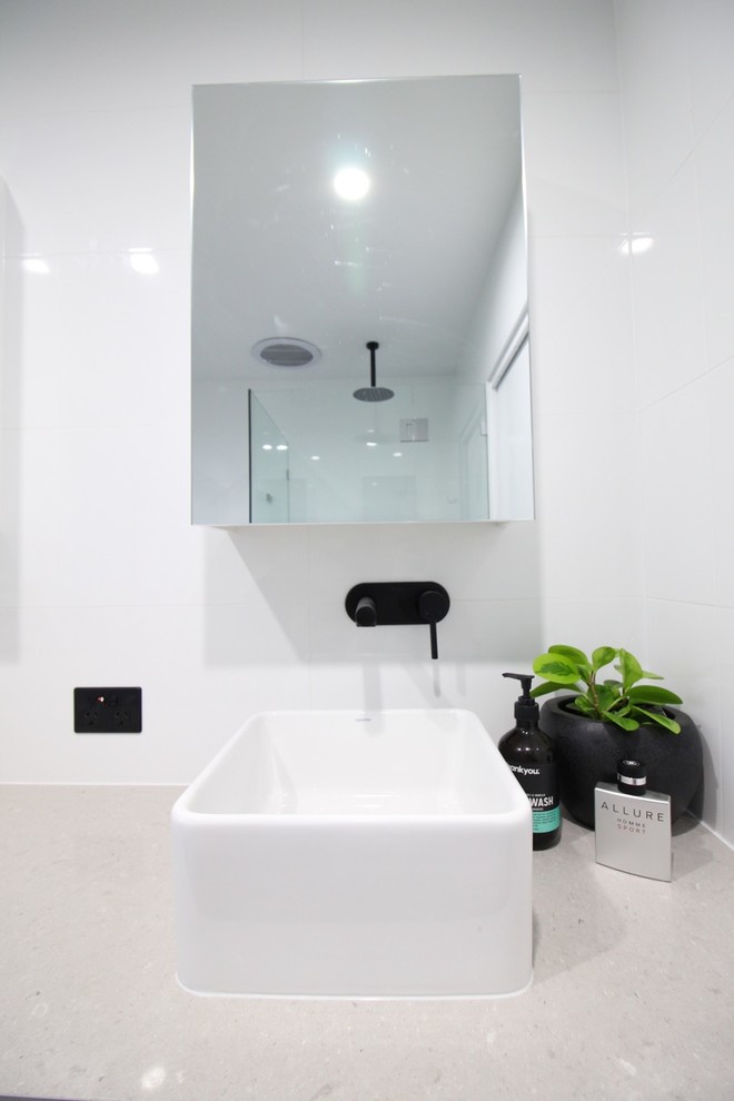 Aménagement d'une salle de bain principale contemporaine avec des portes de placard blanches, une douche d'angle, WC suspendus, un carrelage blanc, des carreaux de béton et un mur blanc.