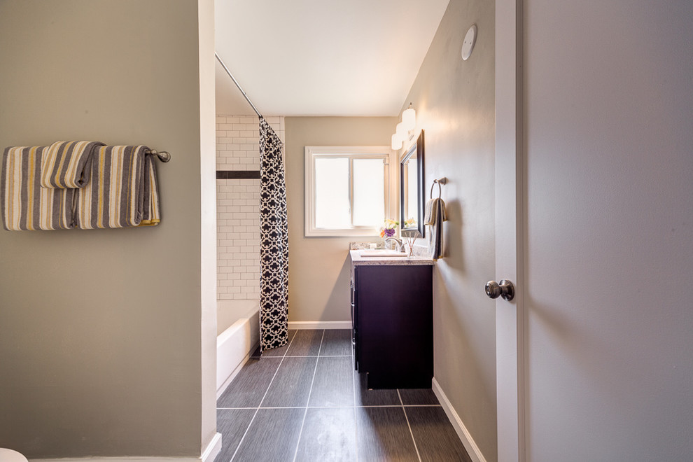 Photo of a medium sized midcentury family bathroom in Sacramento with a built-in sink, shaker cabinets, dark wood cabinets, granite worktops, an alcove bath, a shower/bath combination, a two-piece toilet, grey tiles, ceramic tiles, grey walls and ceramic flooring.