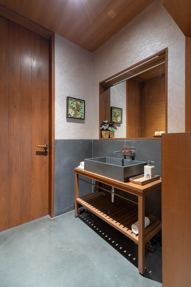 Cette image montre une salle d'eau design en bois brun de taille moyenne avec un carrelage gris, une vasque, un plan de toilette en bois, un sol gris, un plan de toilette marron, meuble simple vasque, meuble-lavabo sur pied et un plafond en bois.