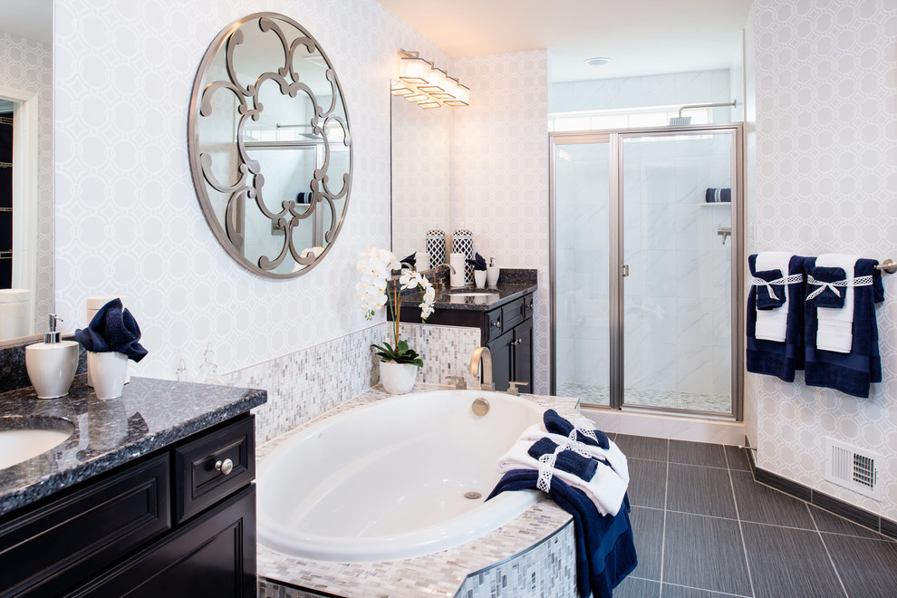 Cette image montre une douche en alcôve traditionnelle avec un lavabo encastré, des portes de placard noires, une baignoire posée, un carrelage noir, un mur rose et un placard avec porte à panneau encastré.