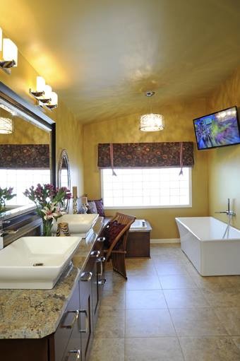 Foto di una grande stanza da bagno padronale design con ante in stile shaker, ante in legno bruno, vasca freestanding, pareti gialle e top in granito