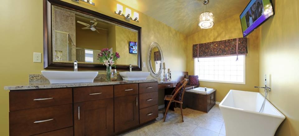 Imagen de cuarto de baño principal contemporáneo grande con armarios estilo shaker, puertas de armario de madera en tonos medios, bañera exenta, paredes amarillas, suelo de pizarra y encimera de granito